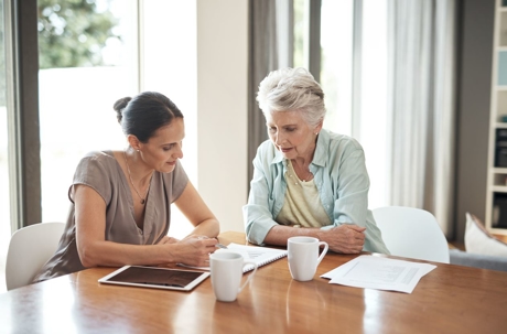 Elderly woman looking at estate planning documents with attorney